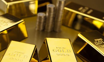 coins and gold bars finance concept e1559728125173