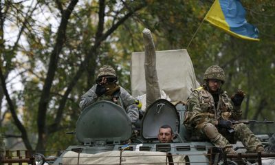 ukrainian servicemen wave as they ride on an armoured vehicle near kramatorsk