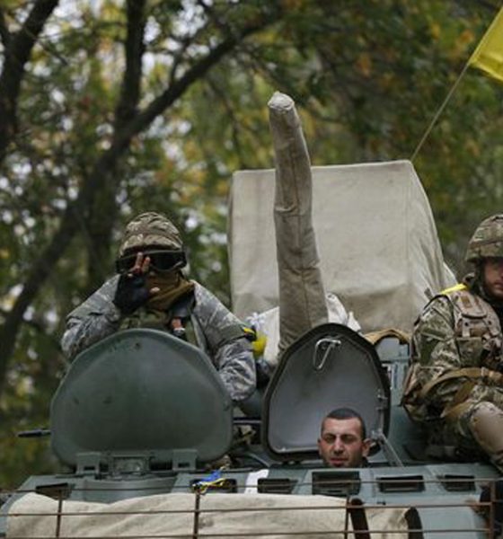 ukrainian servicemen wave as they ride on an armoured vehicle near kramatorsk