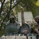 ukrainian servicemen wave as they ride on an armoured vehicle near kramatorsk