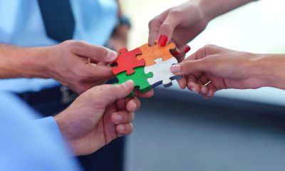 group of business people assembling jigsaw puzzle