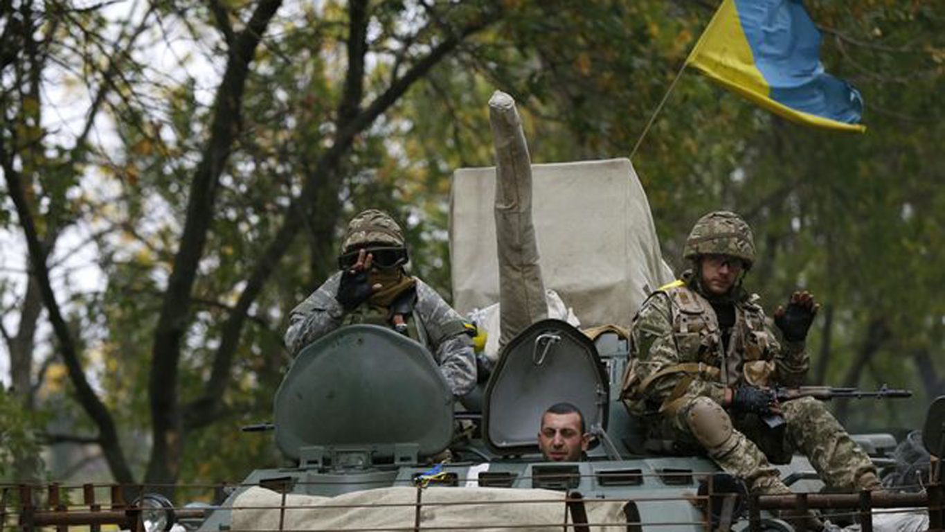 ukrainian servicemen wave as they ride on an armoured vehicle near kramatorsk