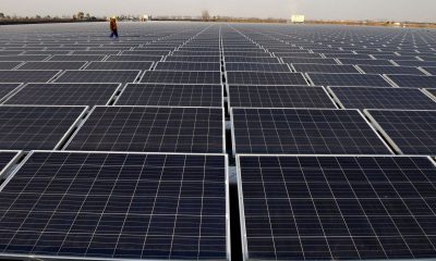 worker walks among solar panels at a floating solar plant developed by china s three gorges group in huainan e1559736599624