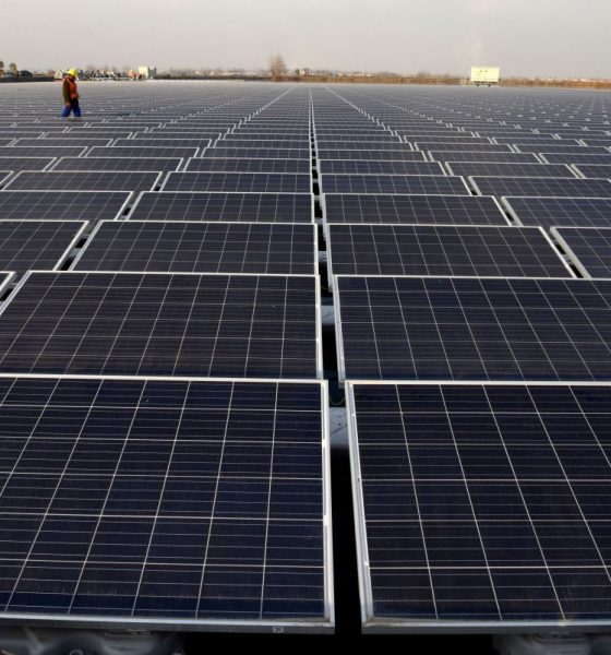 worker walks among solar panels at a floating solar plant developed by china s three gorges group in huainan e1559736599624