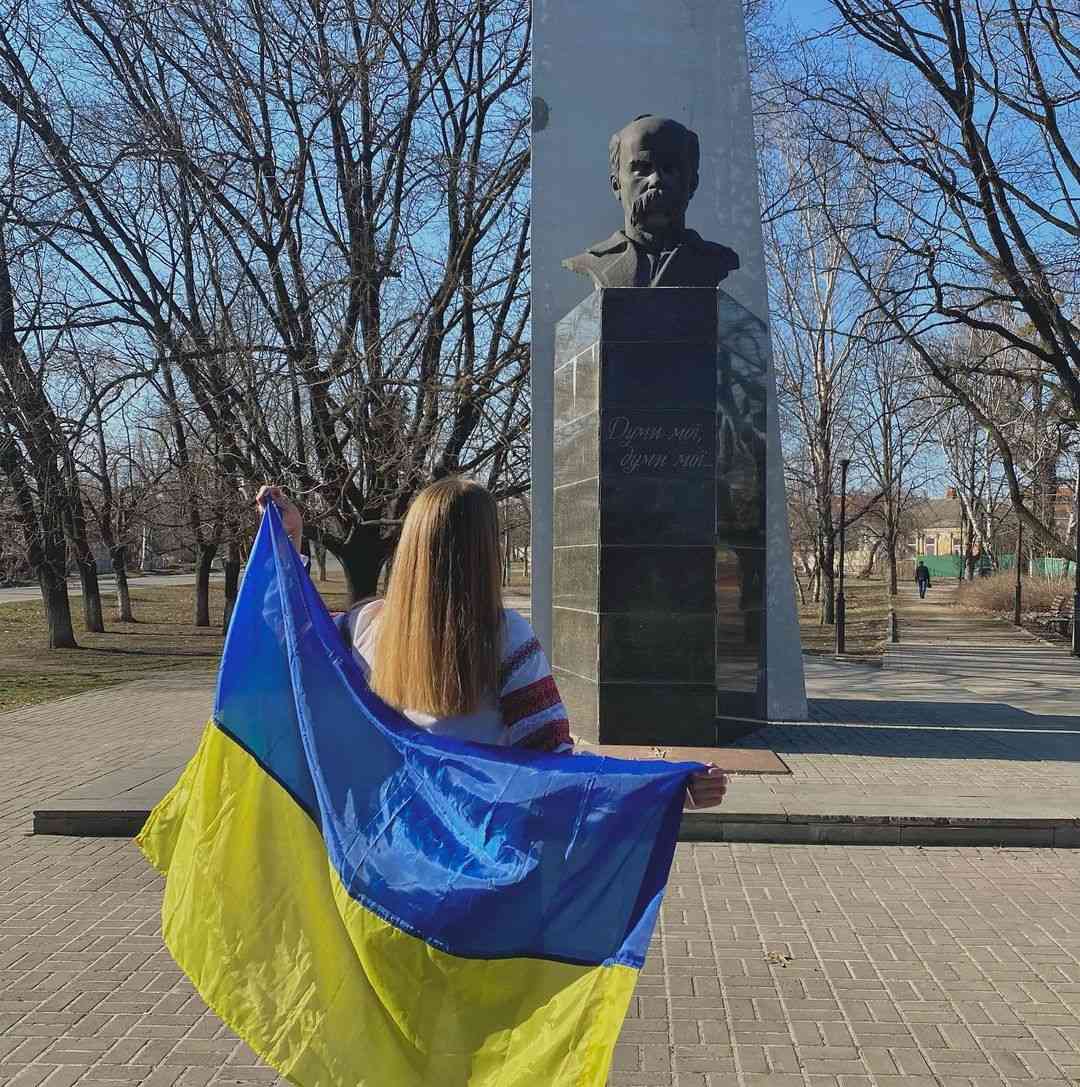 дівчина з прапором біля пам'ятника Шевченка
